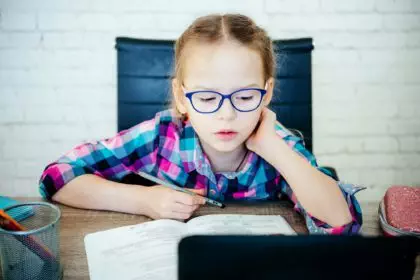 Junior school girl having online lesson at home, distance education for children